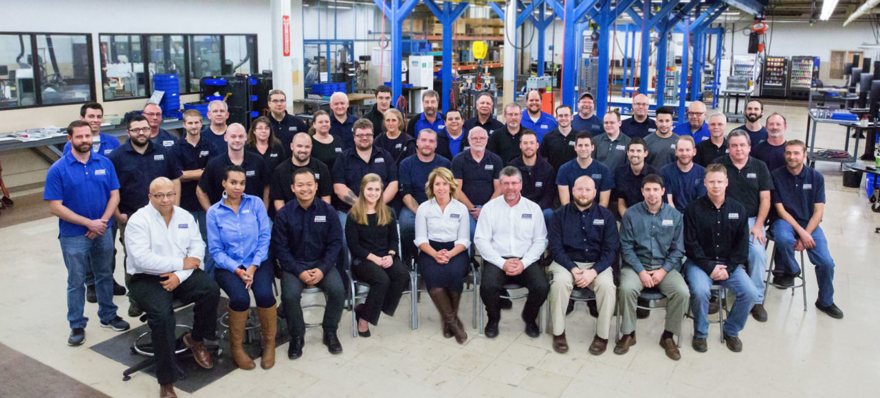 A group of people in blue shirts and black jackets.