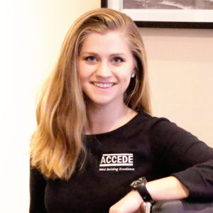 A woman in black shirt holding her arm on the table.