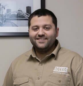 A man in tan shirt smiling for the camera.