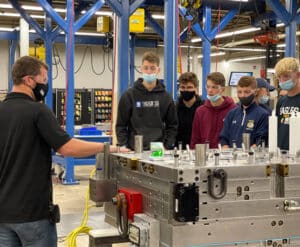 A group of people standing around in front of a machine.